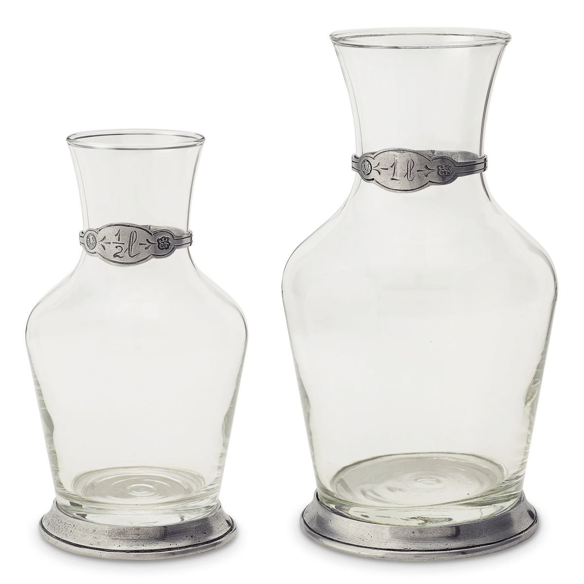 Two clear glass carafes with pewter bands and bases in half liter and one liter sizes