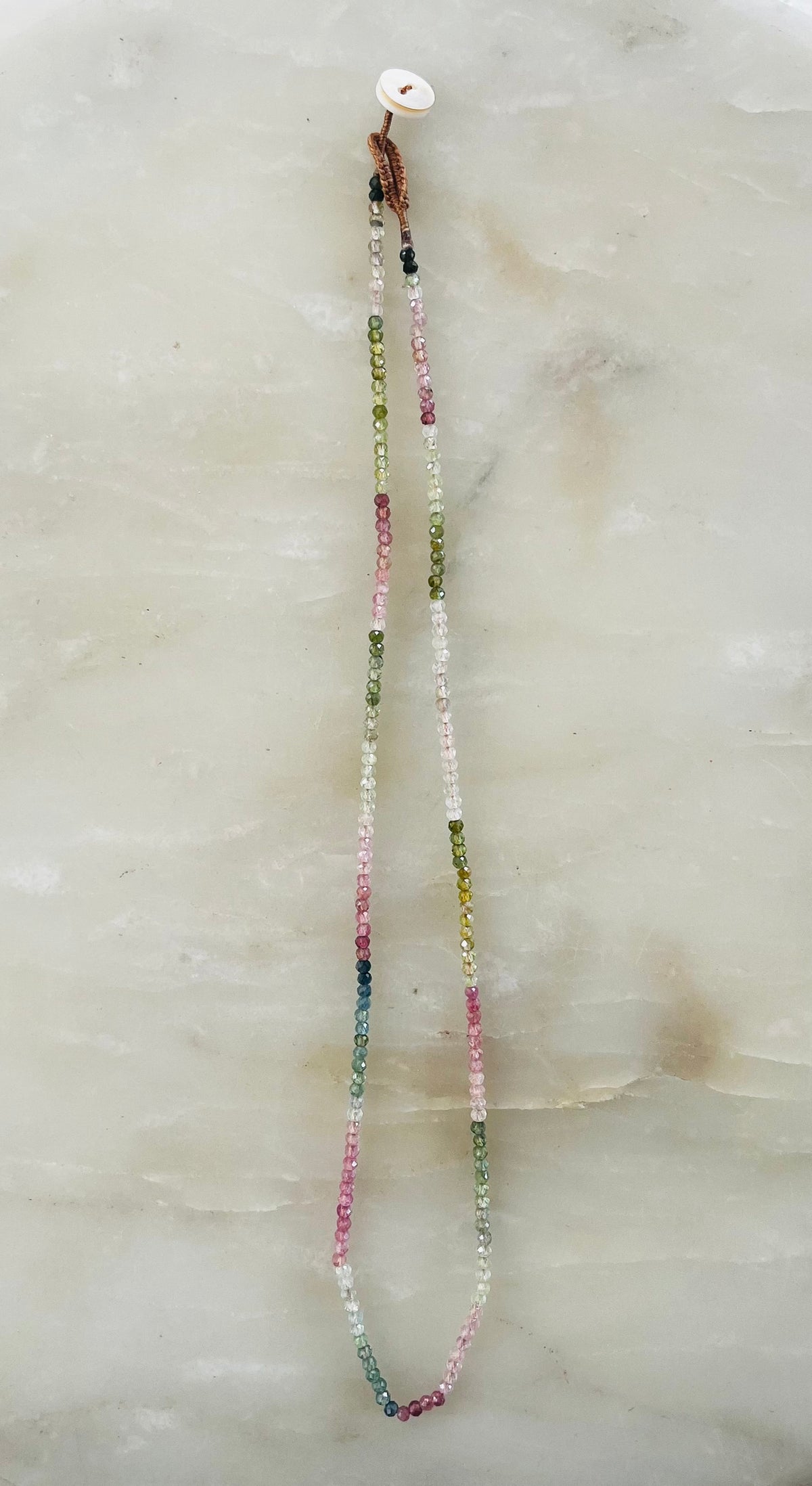 Watermelon tourmaline necklace with multicolored beads on braided cord with white button clasp