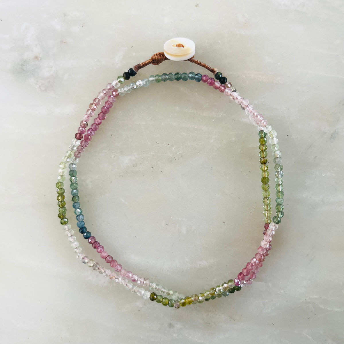 Watermelon tourmaline necklace with multicolored pink, green, and blue beads, white button closure
