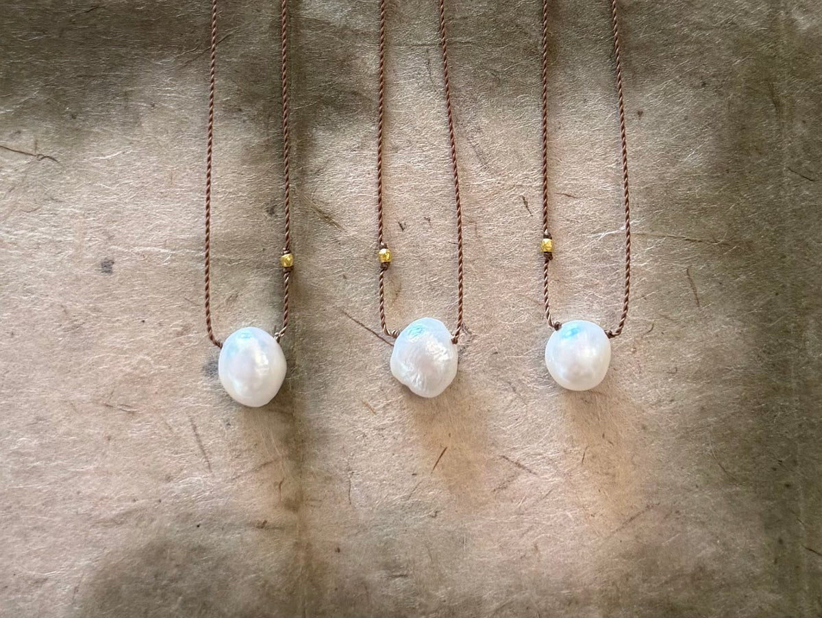 Three Sister Pearls necklaces with white baroque pearls on brown cord with gold accent beads