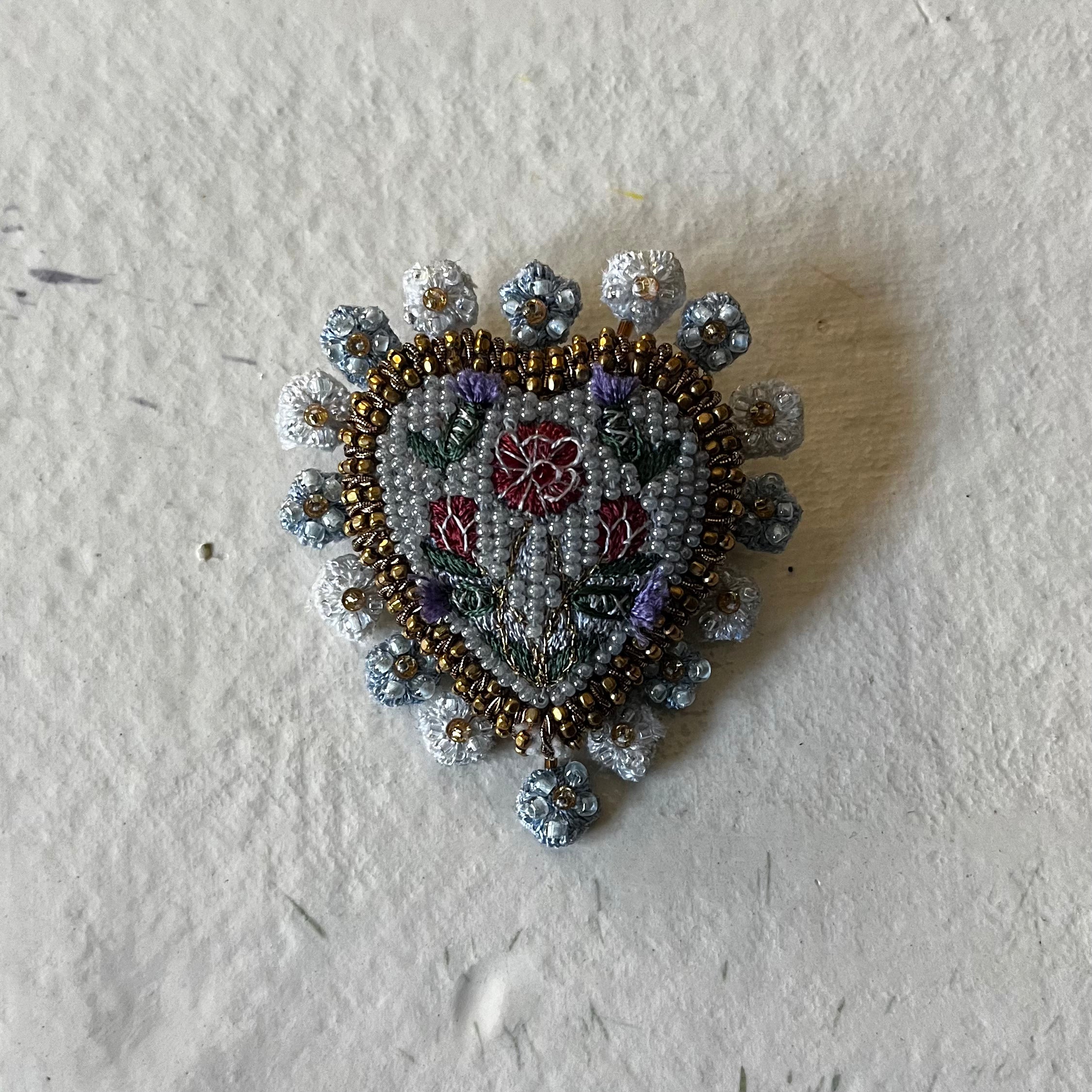 Heritage Heart Brooch with beaded flower design in blue, red, and bronze tones