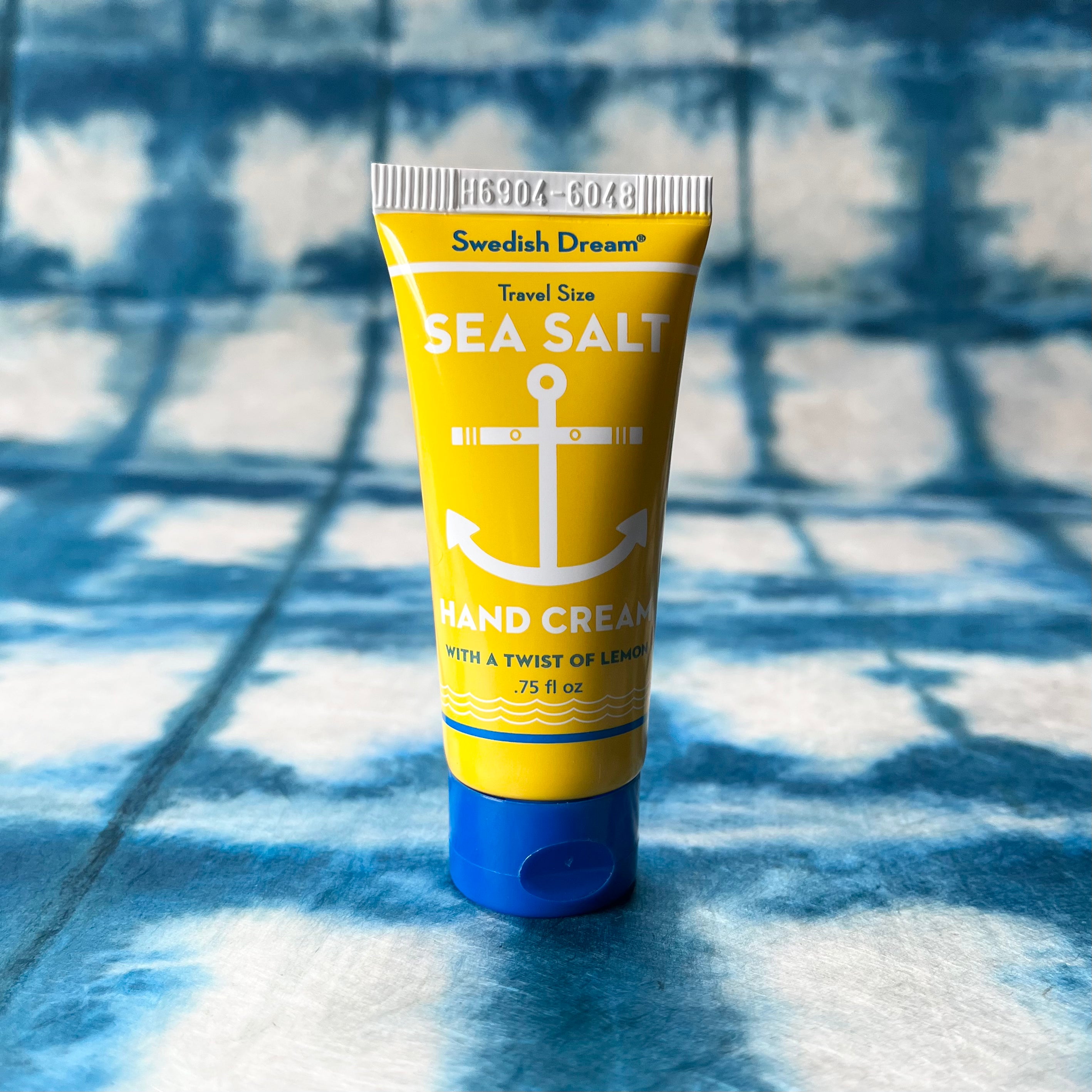 Yellow tube of Swedish Dream Sea Salt hand cream on blue tie-dye fabric