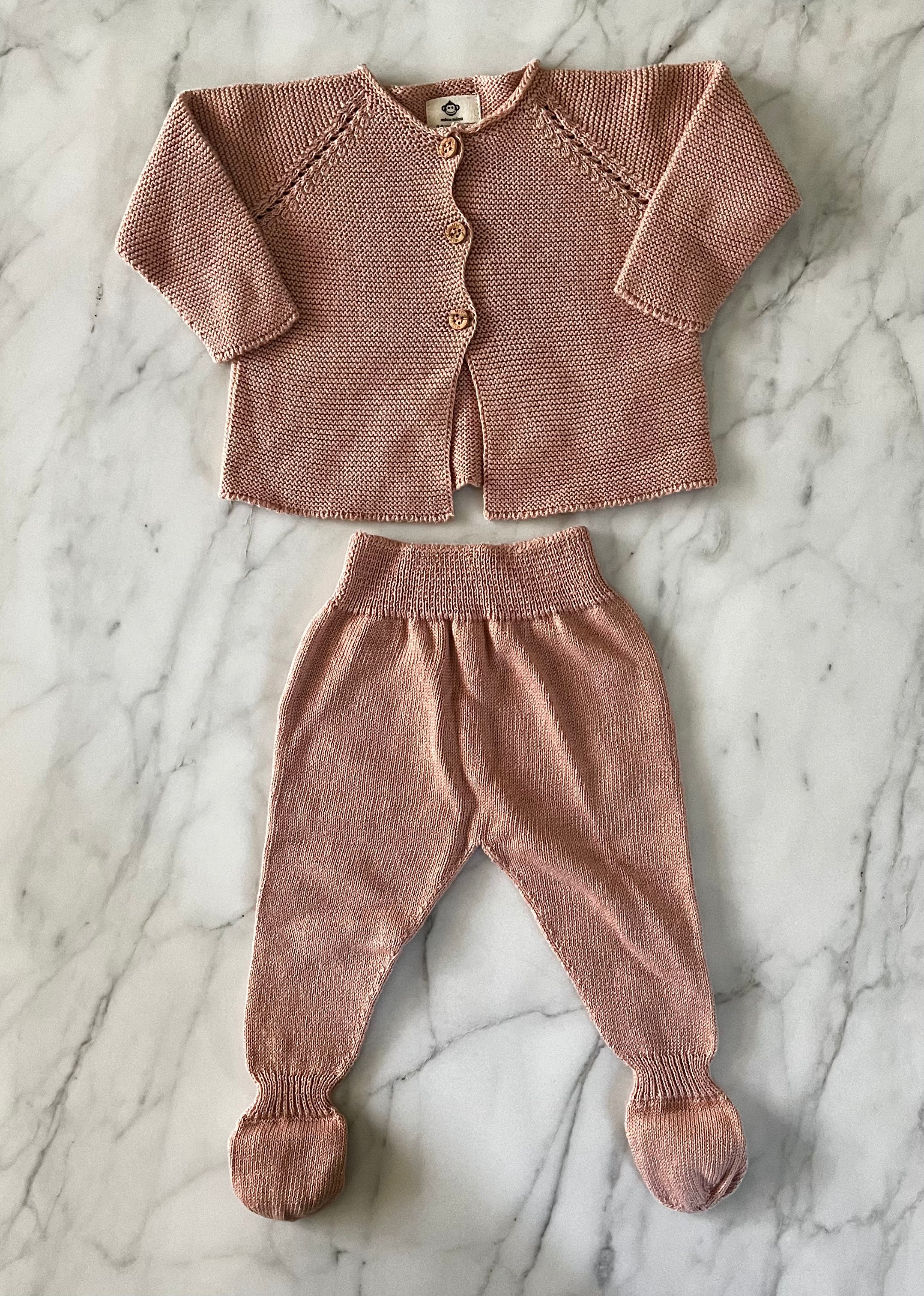 Dusty rose knit baby cardigan with buttons and matching footed pants laid flat