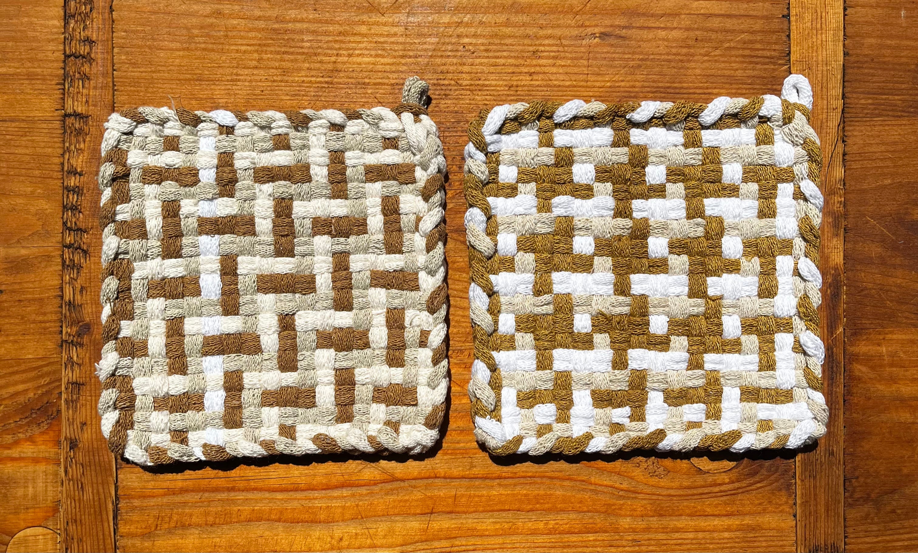 Two Caramel Swirl Potholders with woven white and tan checkerboard pattern on wooden surface