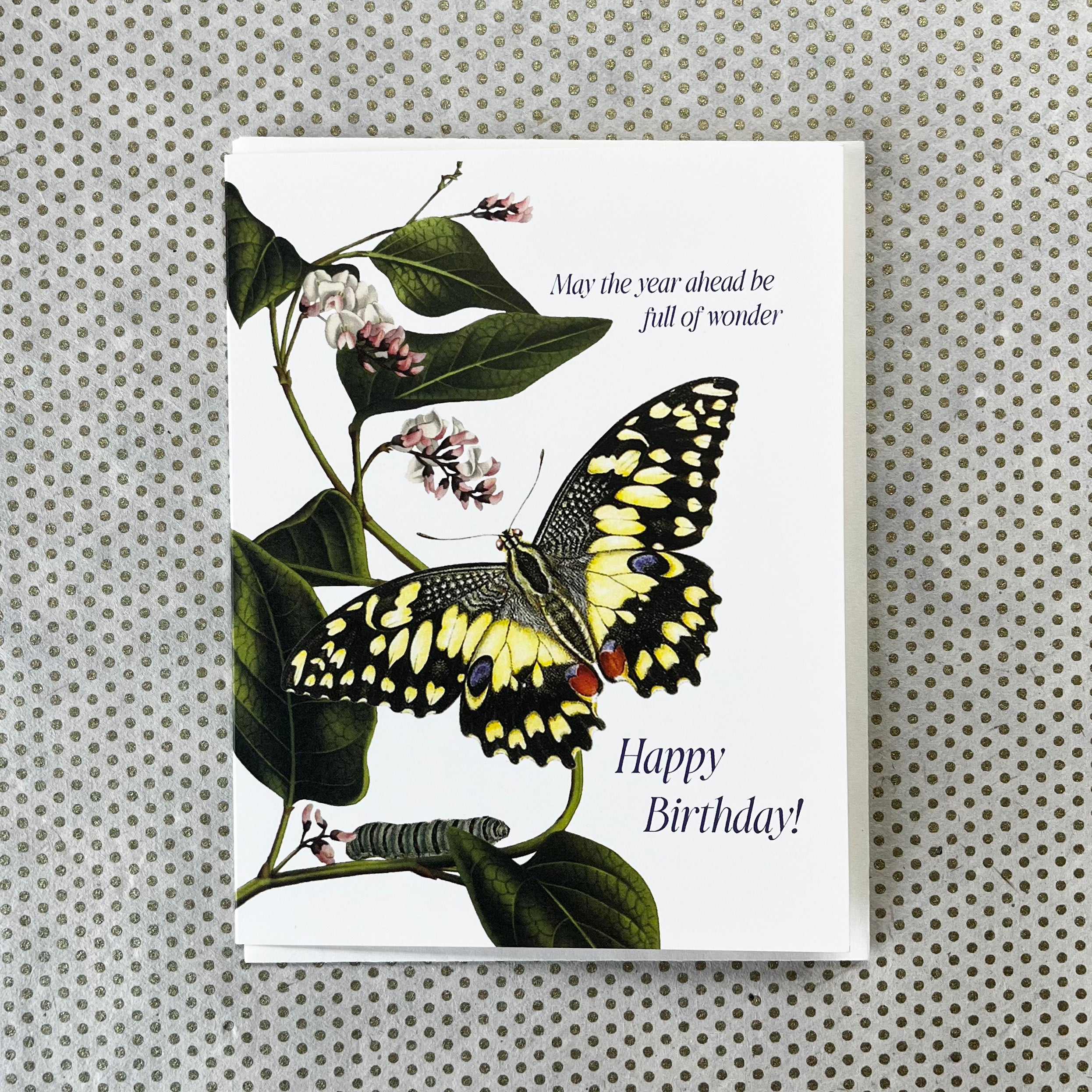 Birthday card featuring yellow and black butterfly illustration on botanical plant with pink flowers