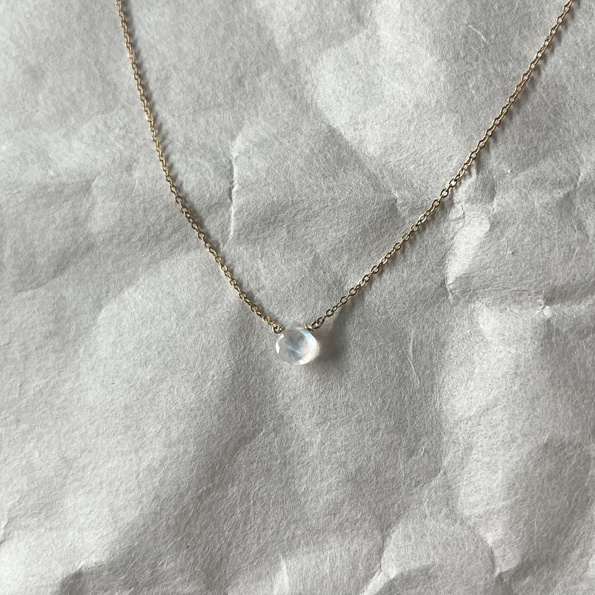 Rainbow moonstone necklace with single translucent stone pendant on delicate gold chain