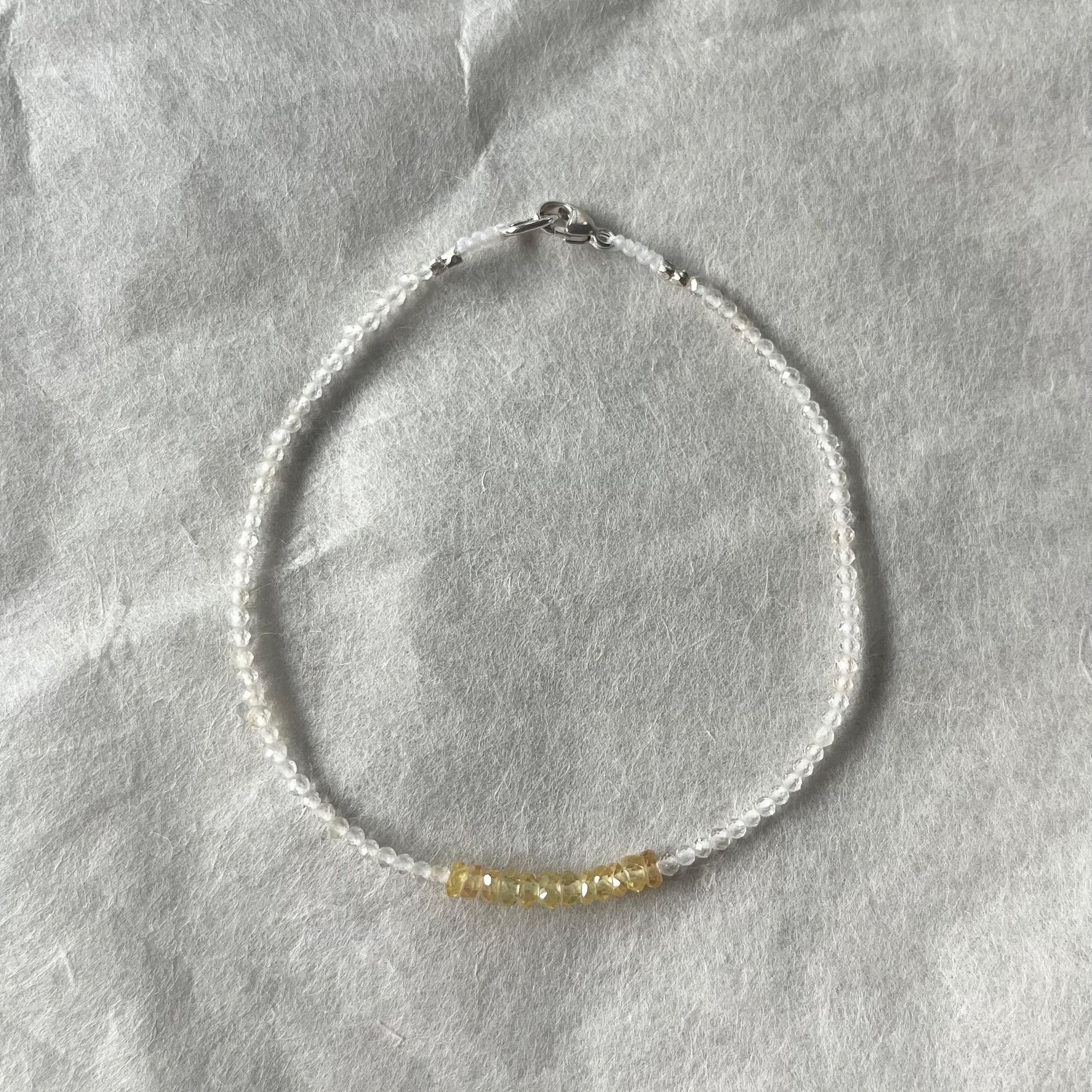 Delicate beaded bracelet with clear white beads and small yellow lemon topaz gemstone center section