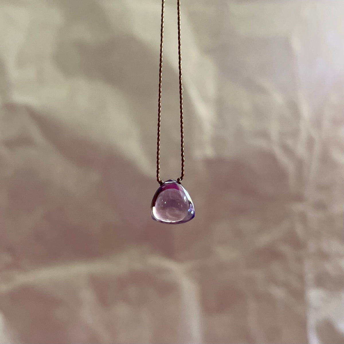 Amethyst necklace with triangular purple gemstone pendant on delicate gold chain