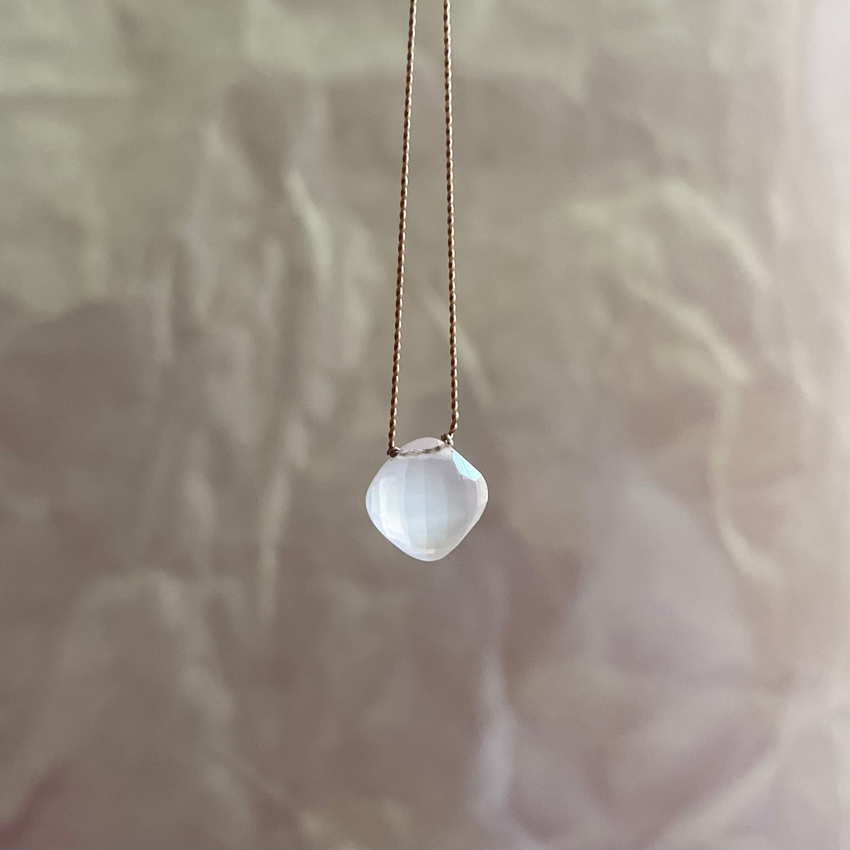 Rose quartz necklace with faceted cushion-cut stone pendant on delicate chain