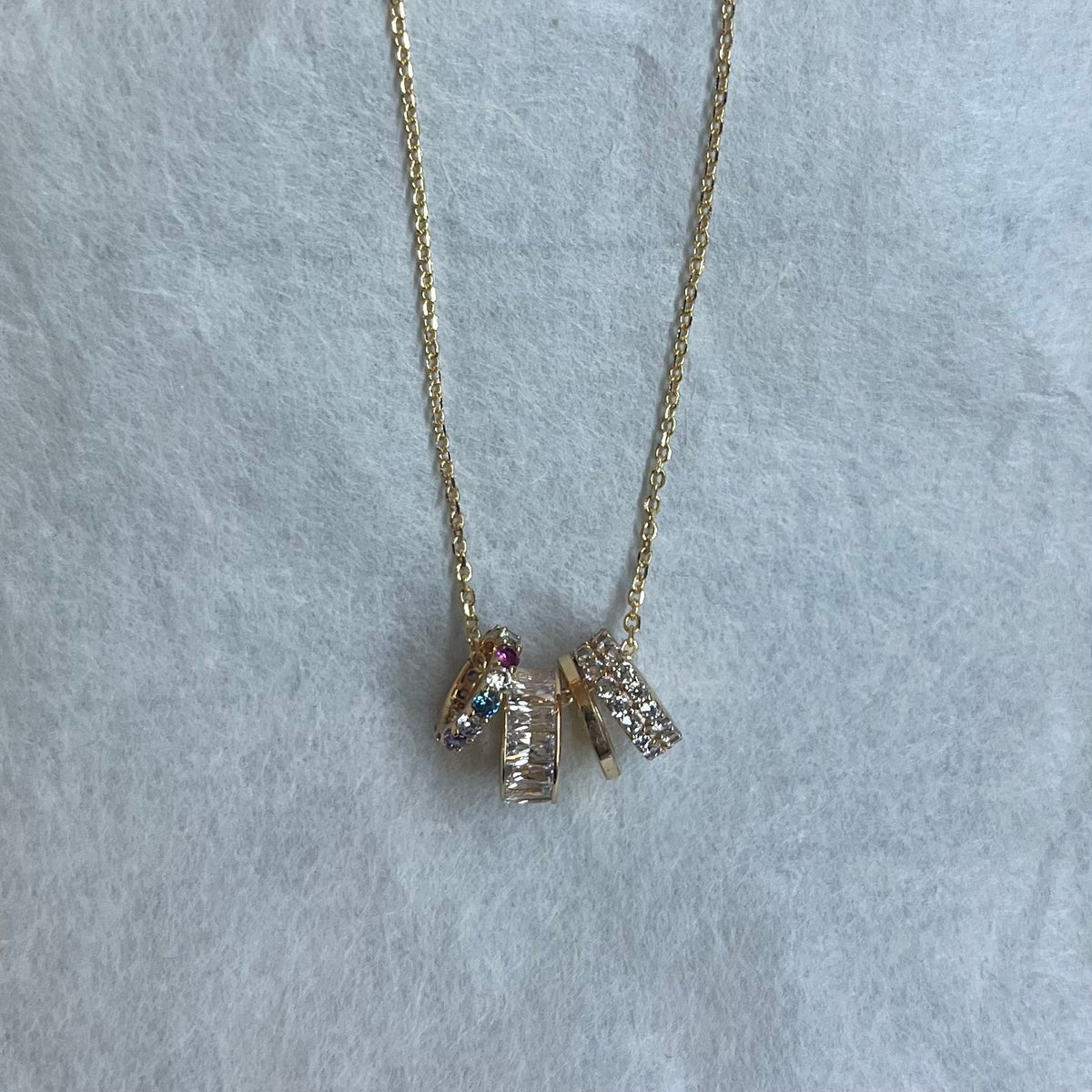 Gold chain necklace with three small textured rondelle charms with rainbow CZ stones