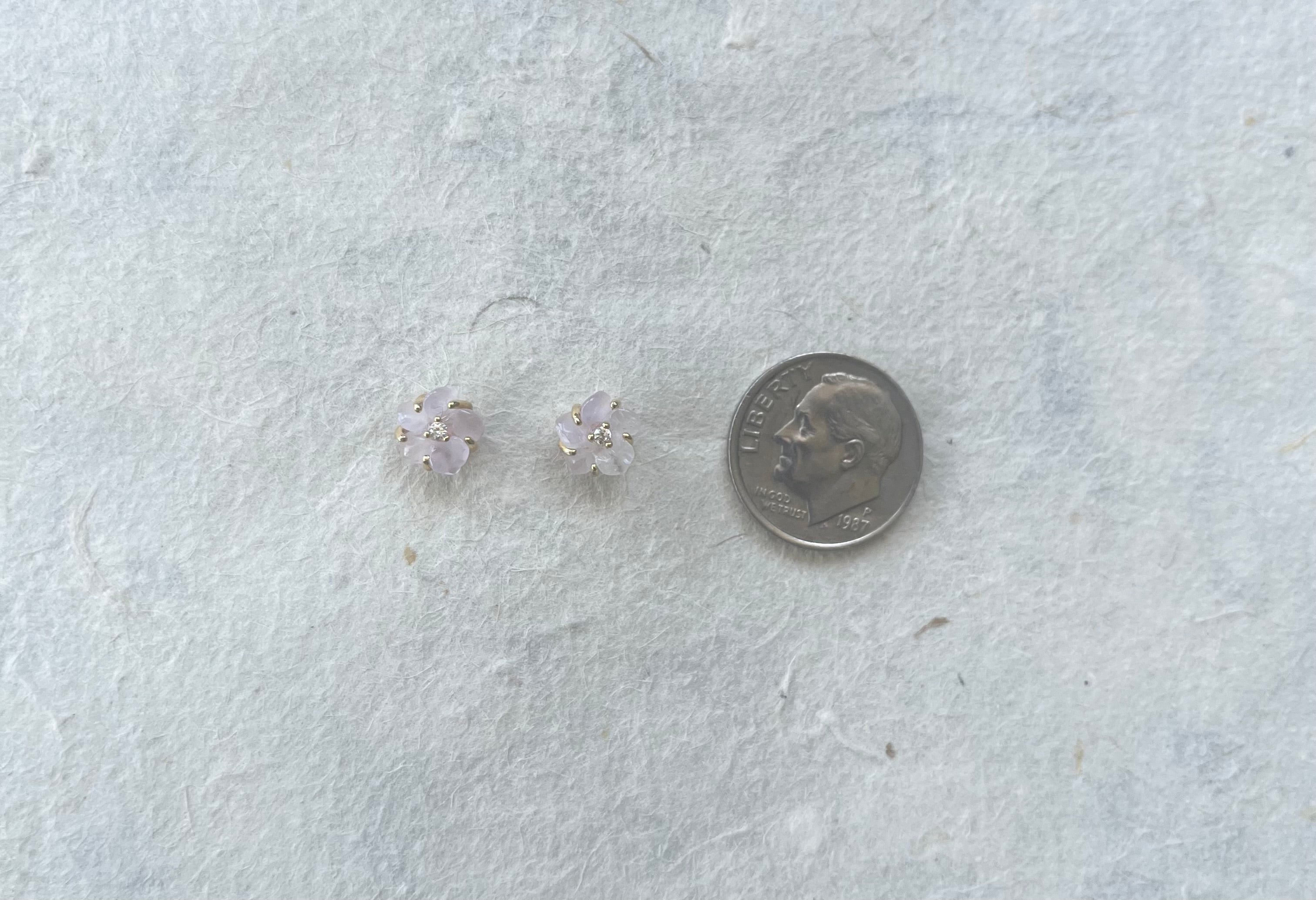 Pair of small rose quartz and CZ flower stud earrings beside dime for scale