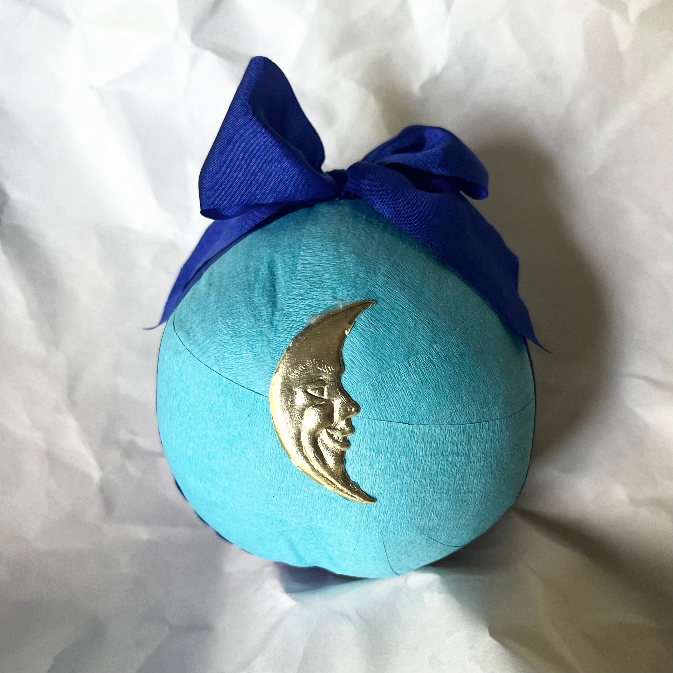 Turquoise surprise ball with gold crescent moon charm and royal blue bow on top