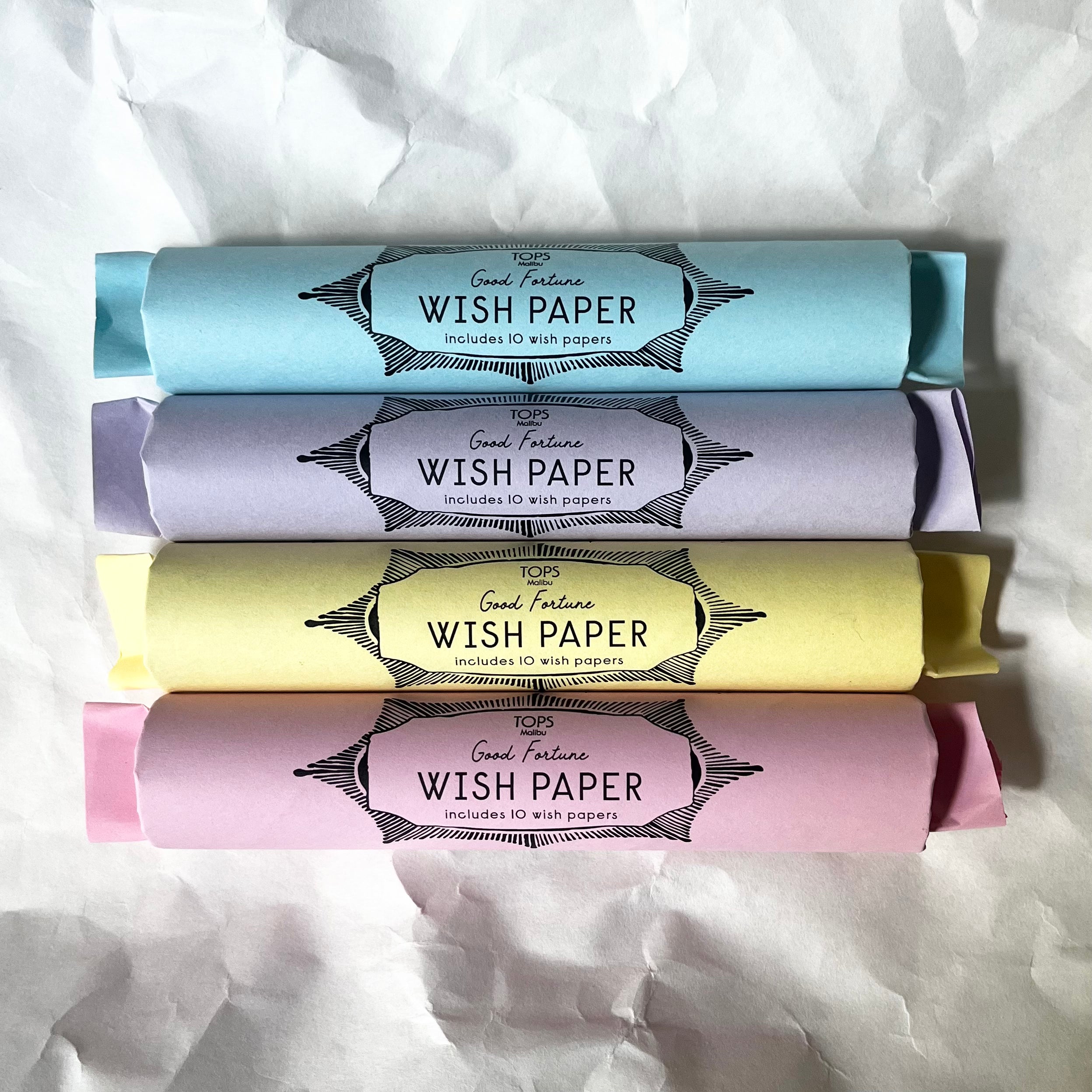 Four stacked Wish Paper packages in blue, purple, yellow, and pink colors