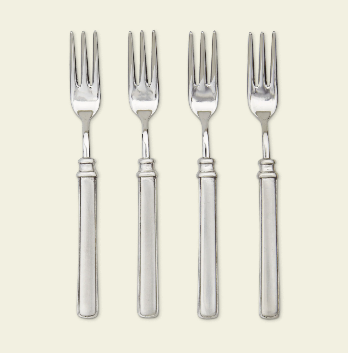 Four silver cocktail forks with three tines and smooth cylindrical handles arranged vertically